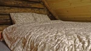 a bed in a room with a wooden wall at Uneallika hubane saunaga majake "Hoburaud" in Pae