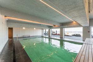 an indoor swimming pool with a view of the ocean at DilemmaSea - App met zeezicht, terras én zwembad in Middelkerke