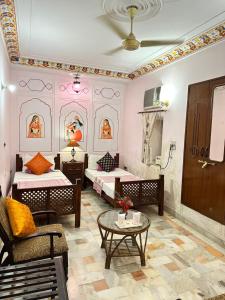 ein Wohnzimmer mit 2 Betten und einem Tisch in der Unterkunft Rawla Mrignayani Palace in Jaipur