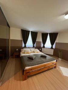 a bedroom with a large bed with pillows on it at Holler Vendégház II. in Bük