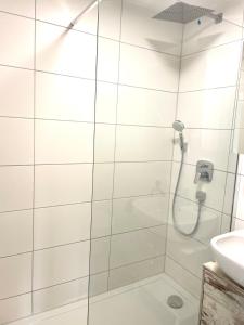 La salle de bains est pourvue d'une douche et d'un lavabo. dans l'établissement Stilvolle Wohnung im Herzen von Immenstadt - Nähe Mittag, Iller, Inselsee, à Immenstadt
