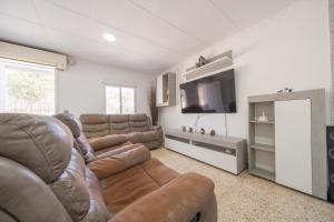 sala de estar con sofá y TV de pantalla plana en HomeHolidaysRentals Adaggio - Costa Barcelona, en Fogars de la Selva