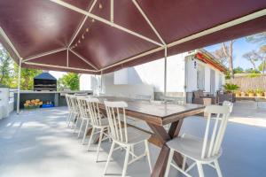 un patio al aire libre con mesa de madera y sillas en HomeHolidaysRentals Adaggio - Costa Barcelona, en Fogars de la Selva