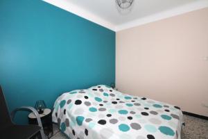 um quarto com uma cama com um cobertor de bolinhas em appartement 2 pieces avec parking et vue sur la marina em Canet-en-Roussillon