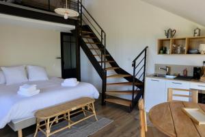 a bedroom with a bed and a spiral staircase at La Grange du Veld in Téteghem