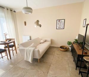a living room with a white couch and a table at Au chalet in Maroilles