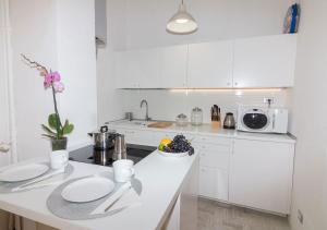 kuchnia z białymi szafkami i białym blatem w obiekcie MILAN stilysh apartment near Metro and Fiera MICO w Mediolanie