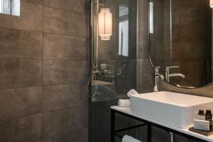 a bathroom with a sink and a shower at The Rock Suites in Skiathos