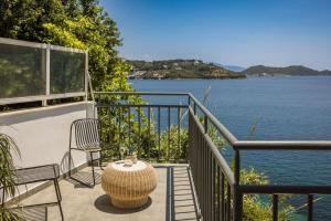 einen Balkon mit einem Tisch und Stühlen sowie Blick auf das Wasser in der Unterkunft The Rock in Skiathos-Stadt