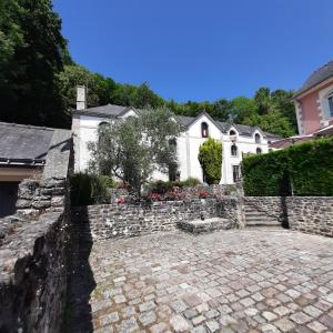 een huis met een stenen hek en een stenen tuin bij SousLesToits 4 étoiles in Dinan