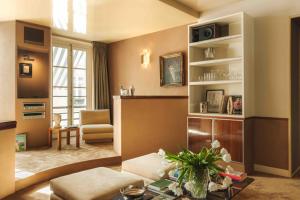 a living room with a couch and a table at Les Suites Cinabre in Paris