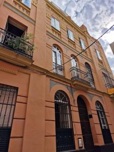 ein hohes Gebäude mit Fenstern und Balkonen darauf in der Unterkunft Precioso Apart. Céntrico y confortable **Wifi-AC** in Sevilla