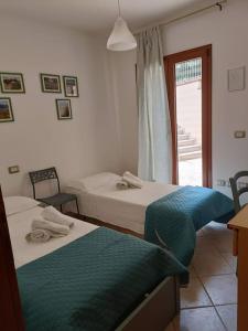 um quarto com 2 camas e uma janela em Giarranas House - Apartment with coutyard em Villacidro