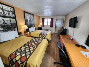 a hotel room with two beds and a desk at WestSpring Inn - Westlake Cleveland in Westlake