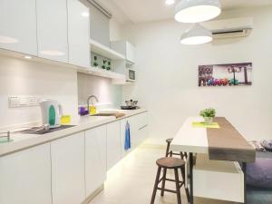 a kitchen with white cabinets and a wooden table at Deluxe suites 3, 1BR, 2-5 pax, Netflix, Georgetown in George Town