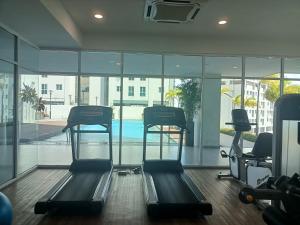 a gym with two exercise bikes and a swimming pool at Deluxe suites 3, 1BR, 2-5 pax, Netflix, Georgetown in George Town +6 photos