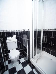 a black and white bathroom with a toilet and a shower at Ceol na Mara Guest House in Enniscrone