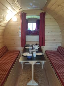 een eetkamer met twee banken en een tafel in een hut bij Barrel in Oostvoorne in Oostvoorne