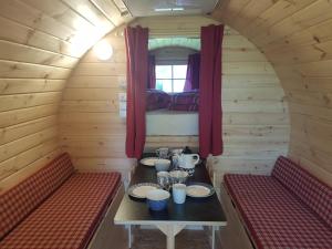 une chambre avec deux bancs et une table dans une cabine dans l'établissement Barrel in Oostvoorne, à Oostvoorne