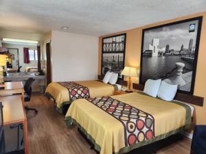 a hotel room with two beds and a desk at WestSpring Inn - Westlake Cleveland in Westlake