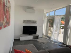 a living room with a tv and a couch and a table at Villa 4 Princesses in Vela Luka