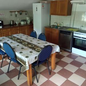 y cocina con mesa, sillas y nevera. en Agroturystyka Makowscy, en Trzcianka