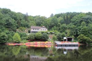 a house on a lake with a bunch of boats at Petite Ferme Embir 