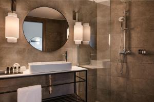 ein Bad mit einem Waschbecken und einem Spiegel in der Unterkunft The Rock in Skiathos-Stadt
