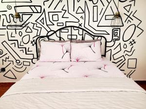 a bedroom with a bed with a black and white wall at Sunset room in Aguada
