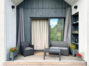 eine Terrasse mit 2 Stühlen, einem Tisch und einem Fenster in der Unterkunft Ivory House in Jūrmala