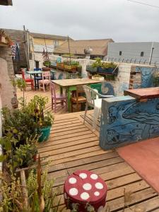 a wooden deck with tables and chairs on a roof at Kom Hostal in Pichilemu