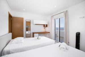2 letti in una camera con vista sull'oceano di Luxury Beachfront 2 Bedroom's Penthouse - Mar do Sol By Centralgarve a Quarteira