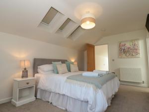 ein Schlafzimmer mit einem Bett und einem Nachttisch mit einer Lampe in der Unterkunft Bailey house in Bainton
