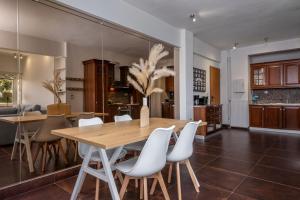 a dining room with a wooden table and white chairs at Relux Sea View 2BD Apartment by BluPine in Athens