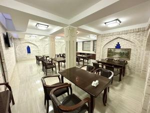 a restaurant with tables and chairs in a room at Antique hotel Imran in Bukhara