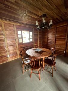 een eetkamer met een houten tafel en stoelen bij Recanto na Serra Bananeiras in Bananeiras