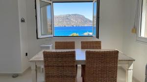 a dining room with a table and chairs and a window at Locals Apartment Karpathos in Karpathos Town