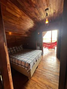 a bedroom with a bed in a wooden house at Recanto na Serra Bananeiras in Bananeiras