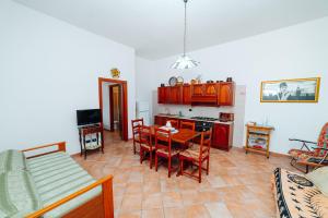 a kitchen and dining room with a table and chairs at Villa Maria in Sanarica