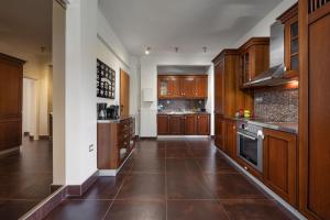 a large kitchen with wooden cabinets and a tile floor at Relux Sea View 2BD Apartment by BluPine in Athens