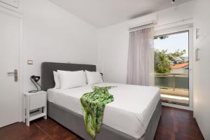 a white bedroom with a bed and a window at Relux Sea View 2BD Apartment by BluPine in Athens