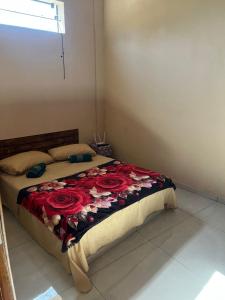 a bedroom with a bed with red roses on it at Casa do Marquinho in Aparecida