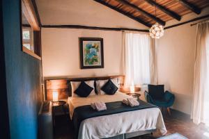 1 dormitorio con 1 cama con 2 toallas en Pousada Villa Serena, en Campos do Jordão