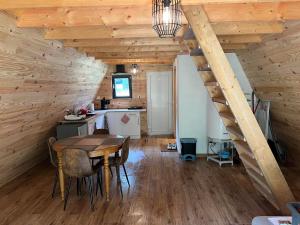 a dining room with a table and a kitchen at La maison en A in Meix-devant-Virton