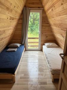 two beds in a room with a window at La maison en A in Meix-devant-Virton