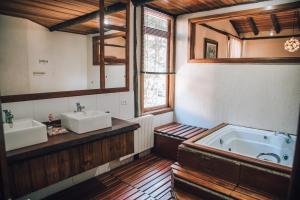 a large bathroom with two sinks and a tub at Pousada Villa Serena in Campos do Jordão