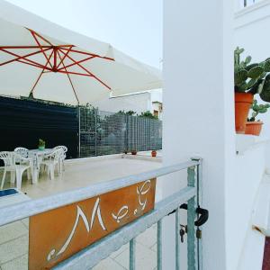 einen Balkon mit einem Tisch, Stühlen und einem Sonnenschirm in der Unterkunft M&G Maison in Crispiano