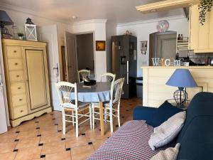 - un salon avec un canapé bleu, une table et des chaises dans l'établissement Le Noisetier, à Cavalaire-sur-Mer