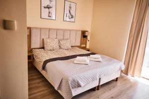 a bedroom with a bed with two towels on it at Villa Lima in Ustka