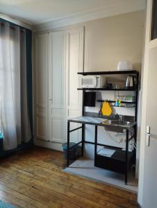 - une cuisine avec une table et un évier dans la chambre dans l'établissement Le Nid - Studios, à Chartres